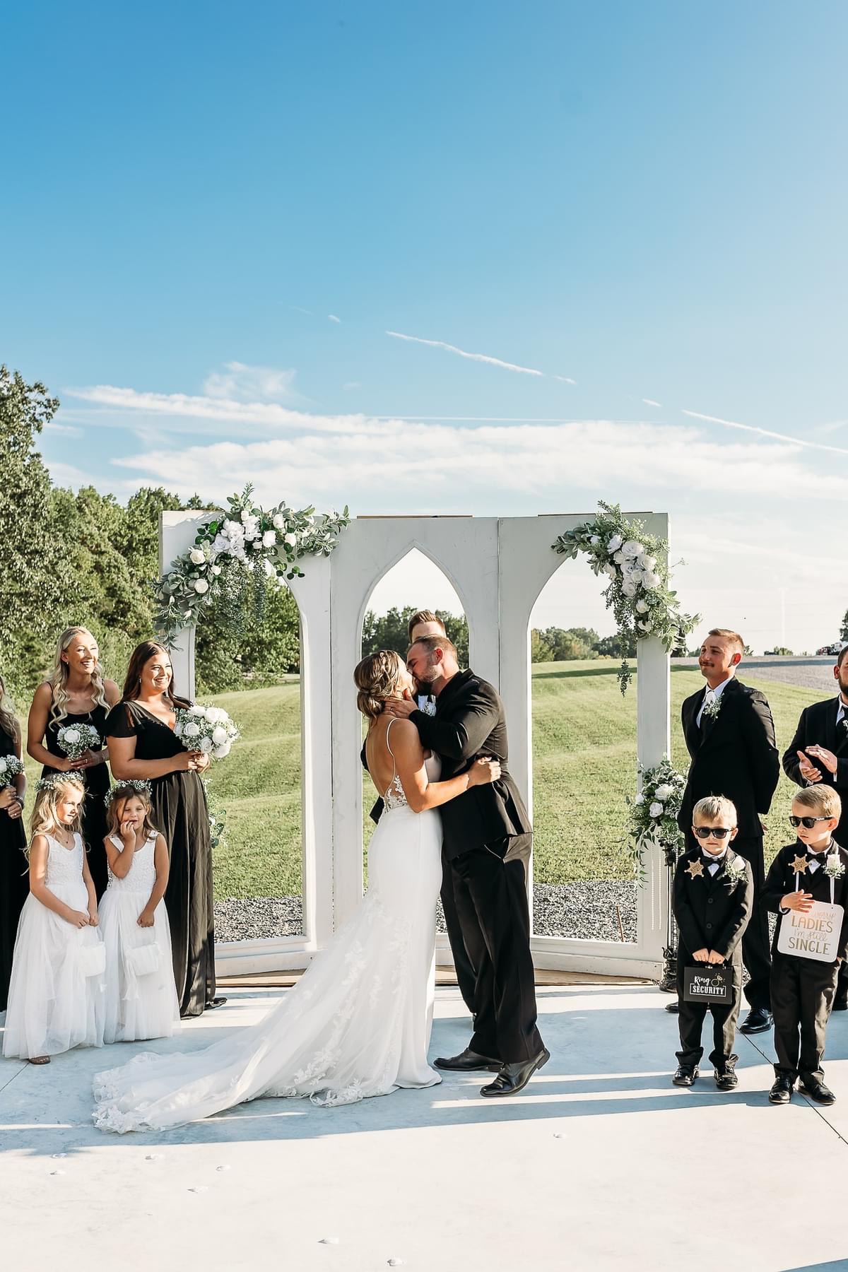 Kiss the bride moment outside on patio at The Meadows Event Venue