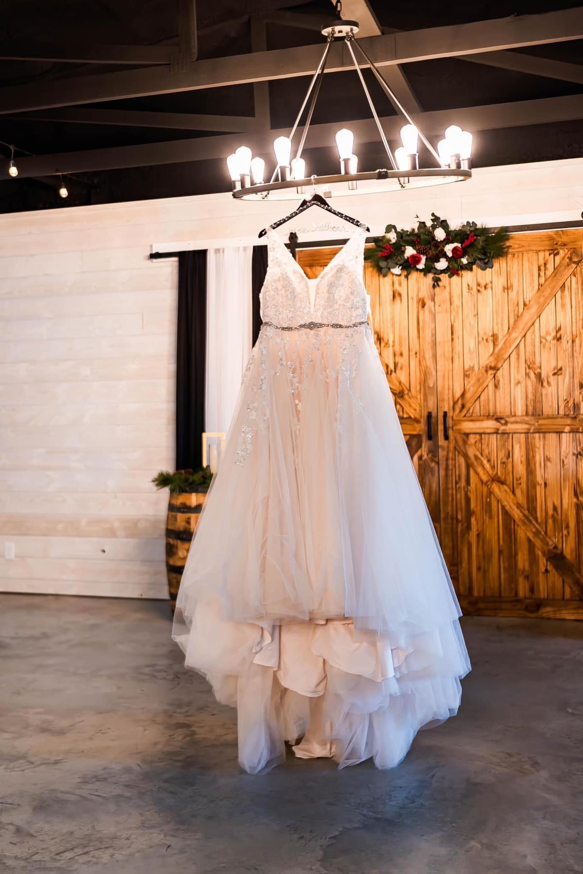 The Meadows Event Venue Image Gallery: Hanging wedding dress in main room of the venue.